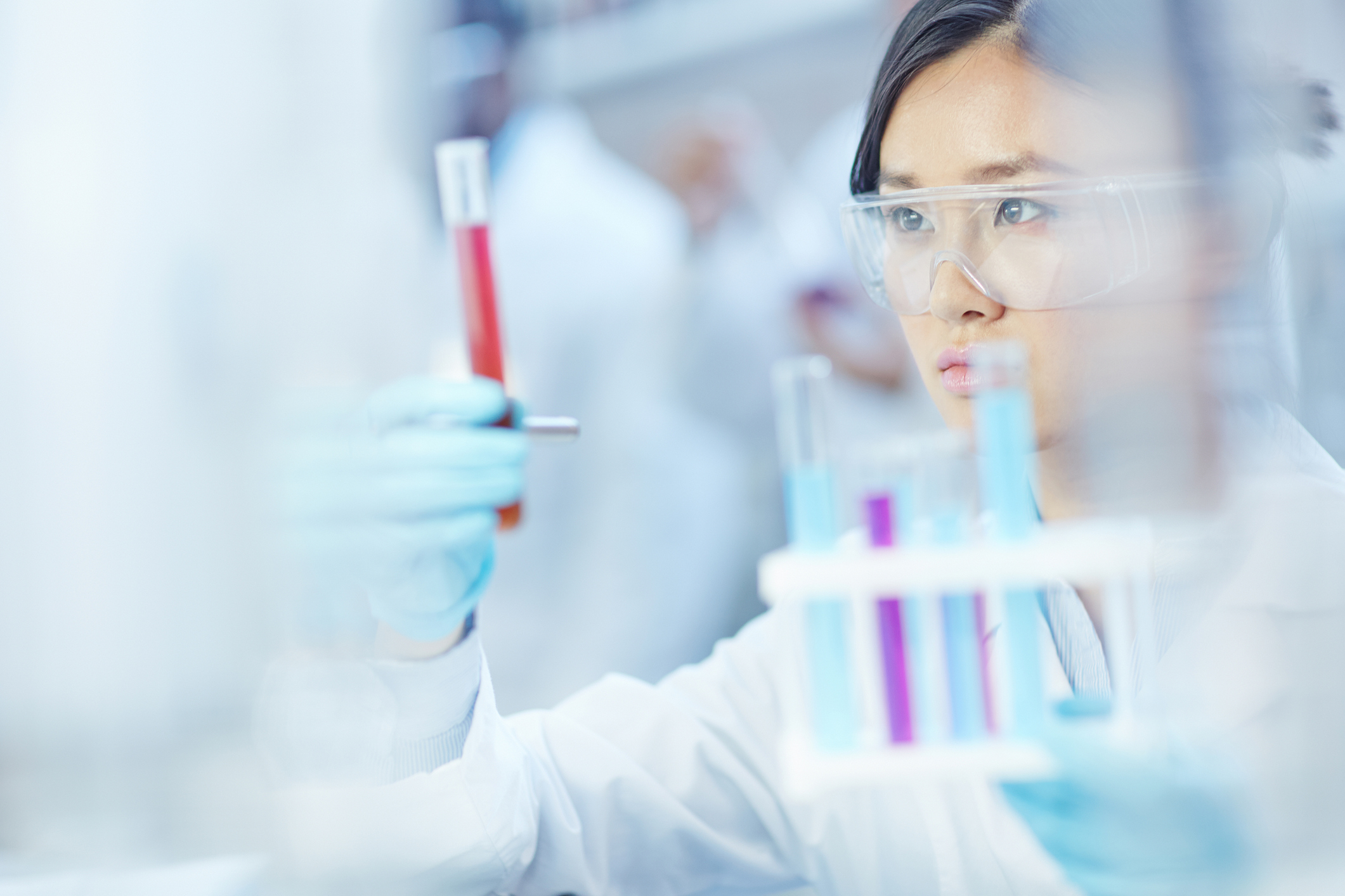 Research scientist conducting experiments in the laboratory, analyzing contents of a test tube