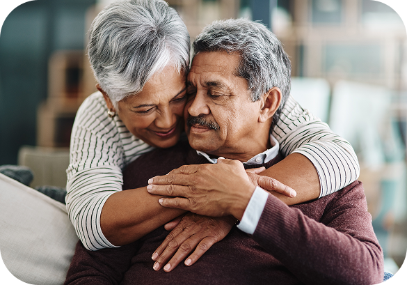 Older couple embracing warmly at home.