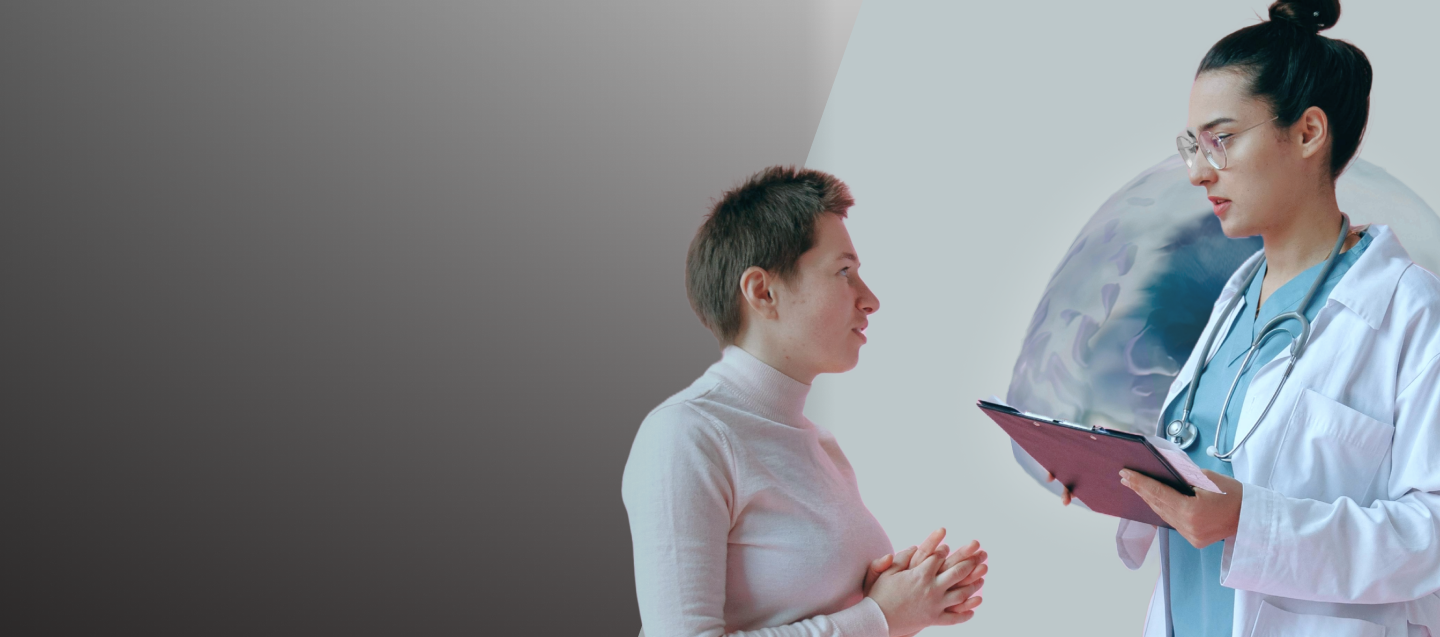 A doctor wearing a white lab coat and teal scrubs discussing options with their patient wearing a light pink turtleneck sweater set against a gray background.
